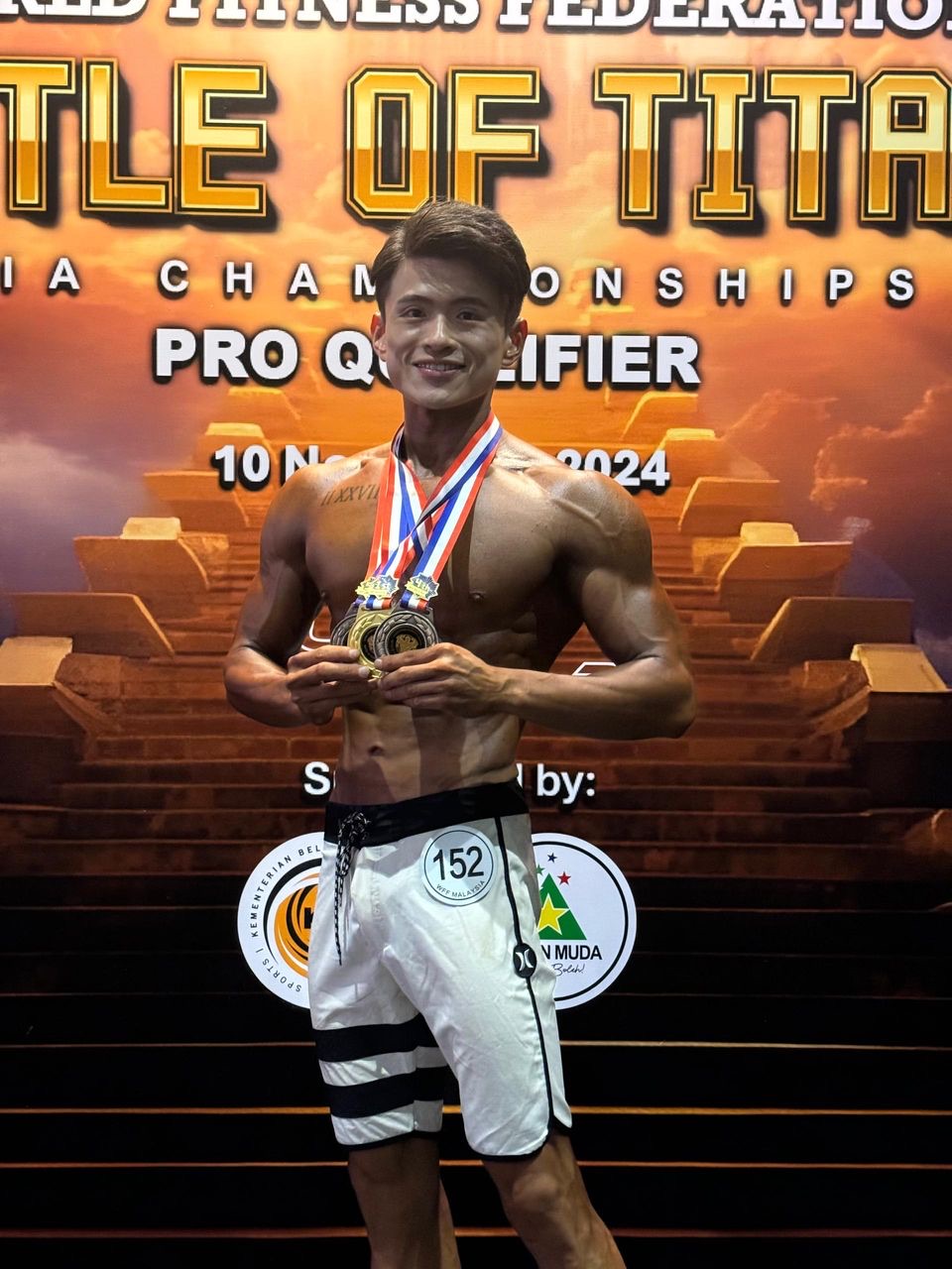 Jun, co-founder of Lazy Diet, holding his medals at a fitness championship